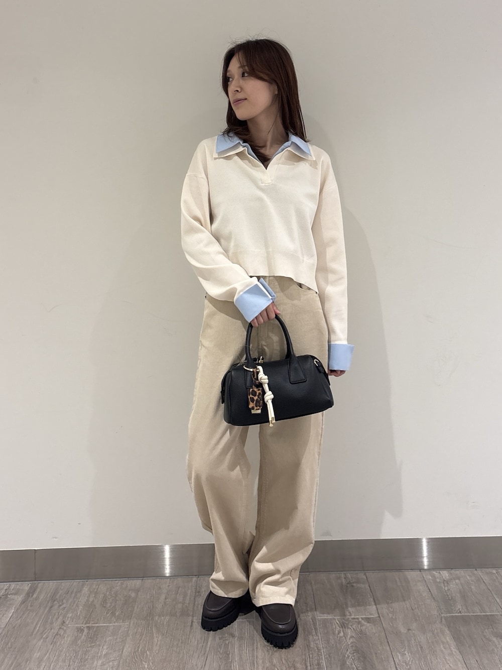 ホワイト系のニット/セーター、ベージュ系のその他パンツ、ブラック系のボストンバッグを着用したレディースの秋コーディネートの1枚目の写真