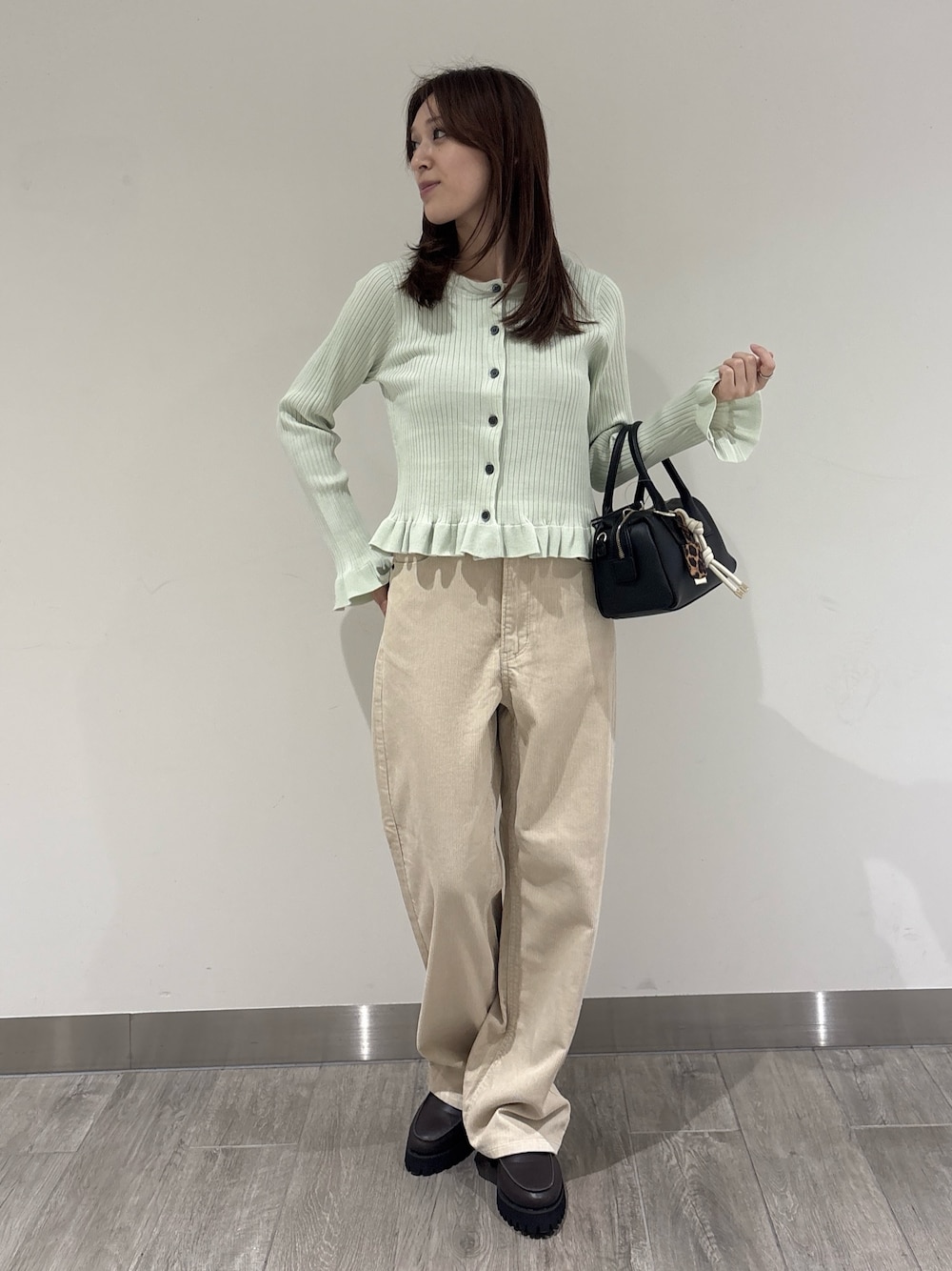 ベージュ系のその他パンツ、グリーン系のニット/セーターを着用したレディースの秋コーディネートの1枚目の写真