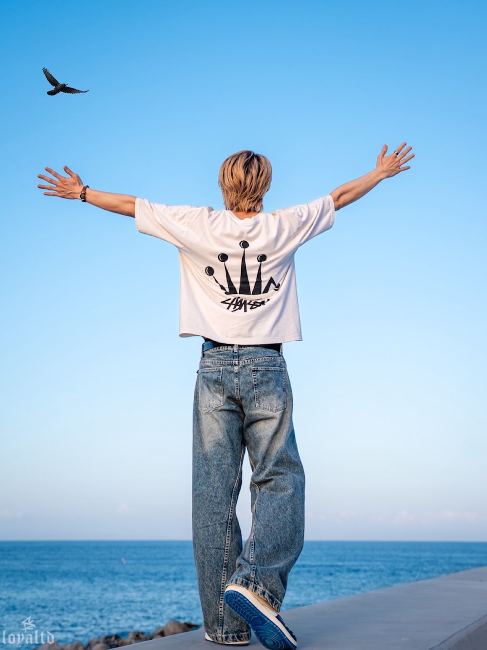ブルー系のデニムパンツ、ホワイト系のTシャツ/カットソー、ブルー系のスニーカーを着用したメンズの夏コーディネートの1枚目の写真