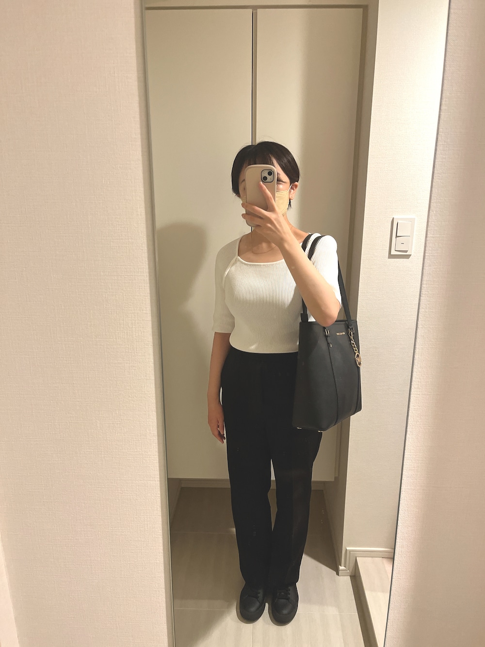 ブラック系のその他パンツ、ホワイト系のニット/セーター、ブラック系のトートバッグを着用したレディースの夏コーディネートの1枚目の写真
