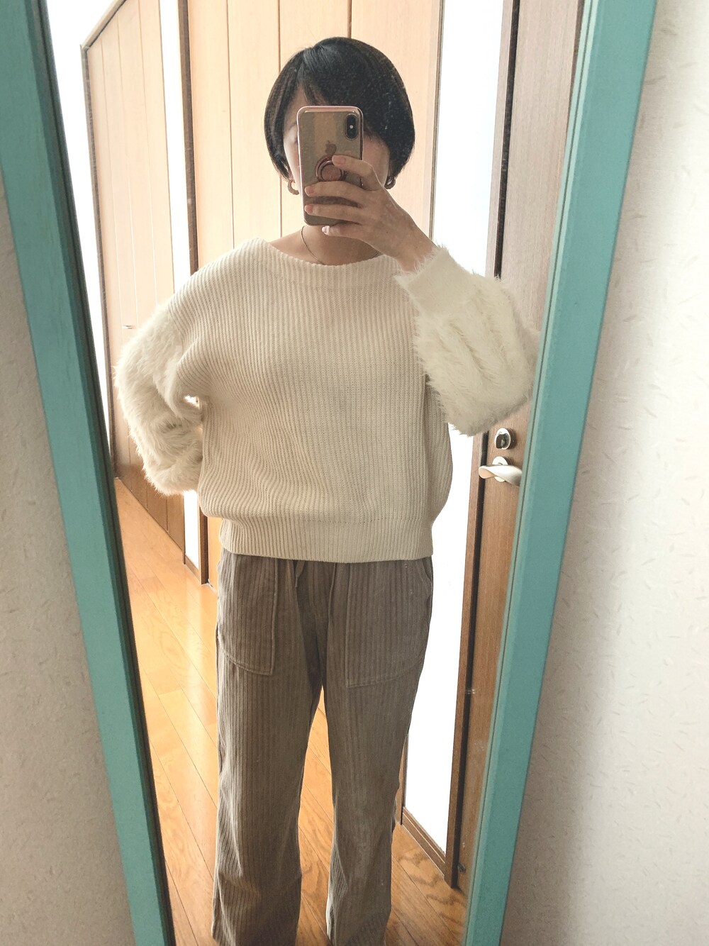 ホワイト系のニット/セーター、グレー系のパンツを着用したレディースの冬コーディネートの1枚目の写真