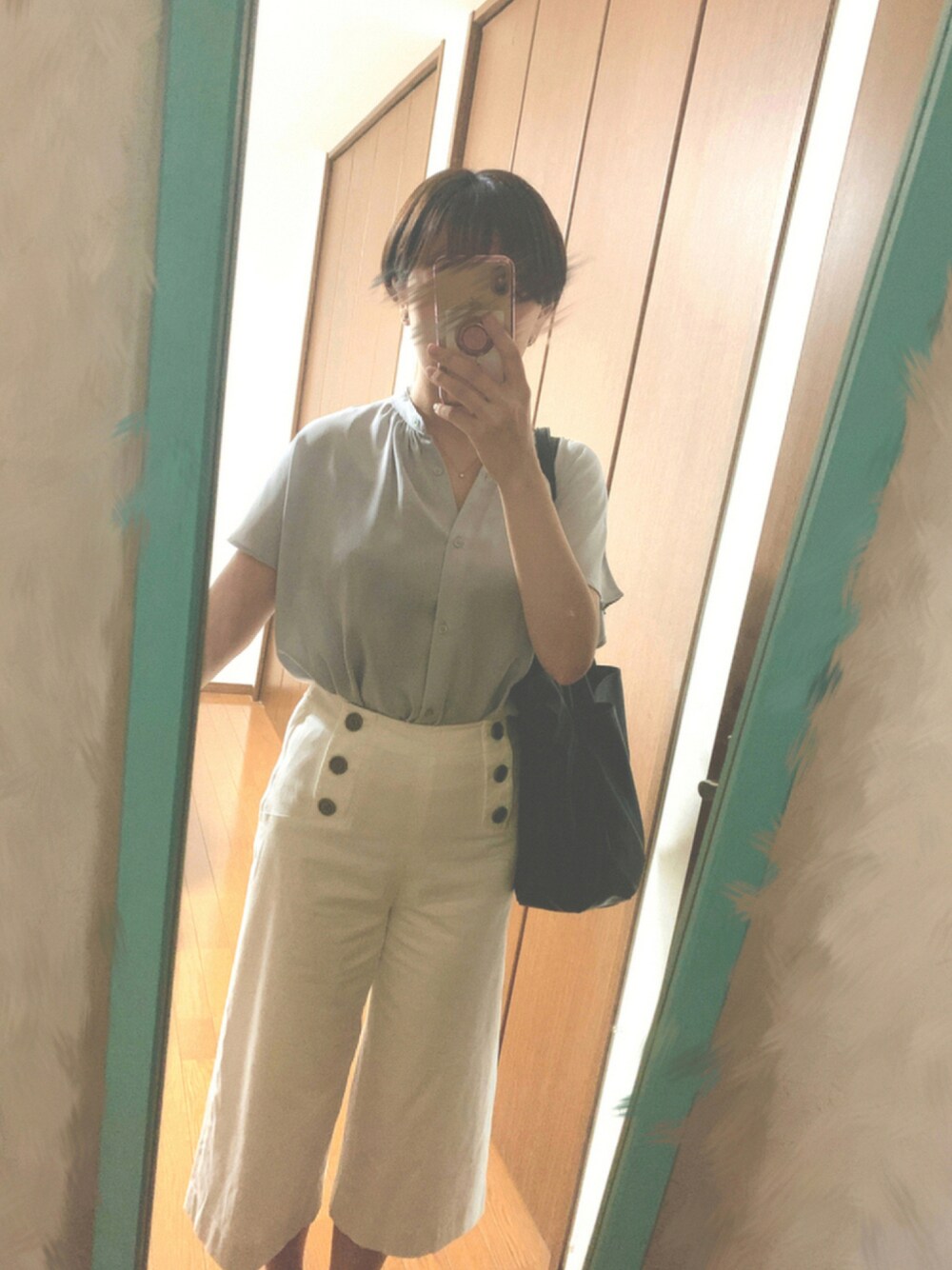 ブルー系のシャツ/ブラウス、ブラック系のトートバッグ、ホワイト系のパンツを着用したレディースの夏コーディネートの1枚目の写真