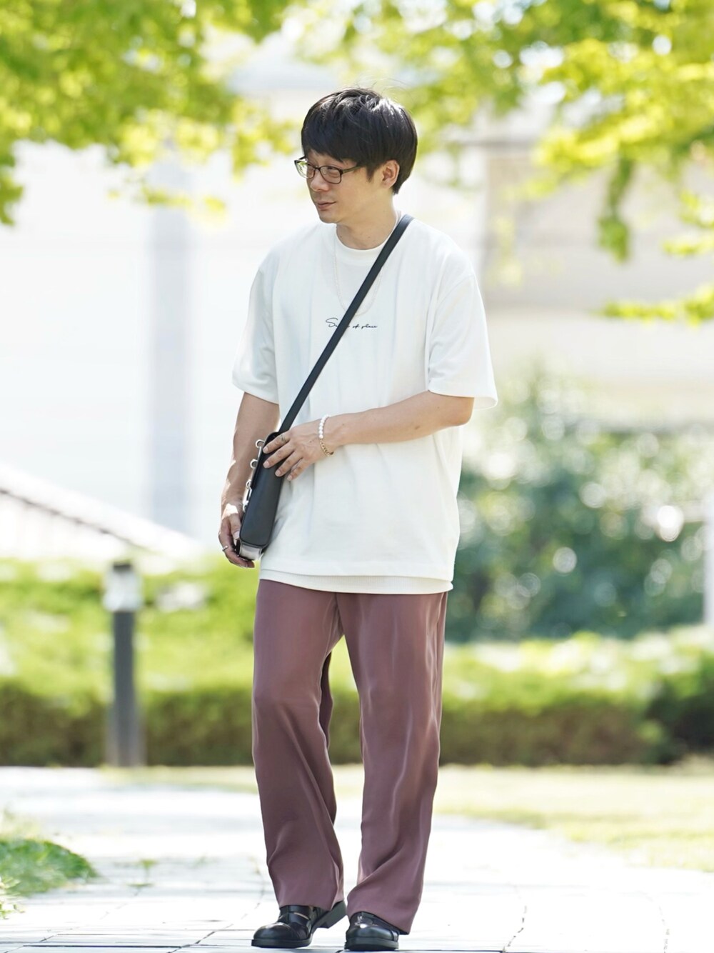 ホワイト系のTシャツ/カットソー、ブラウン系のその他パンツ、ブラック系のサンダルを着用したメンズの夏コーディネートの1枚目の写真