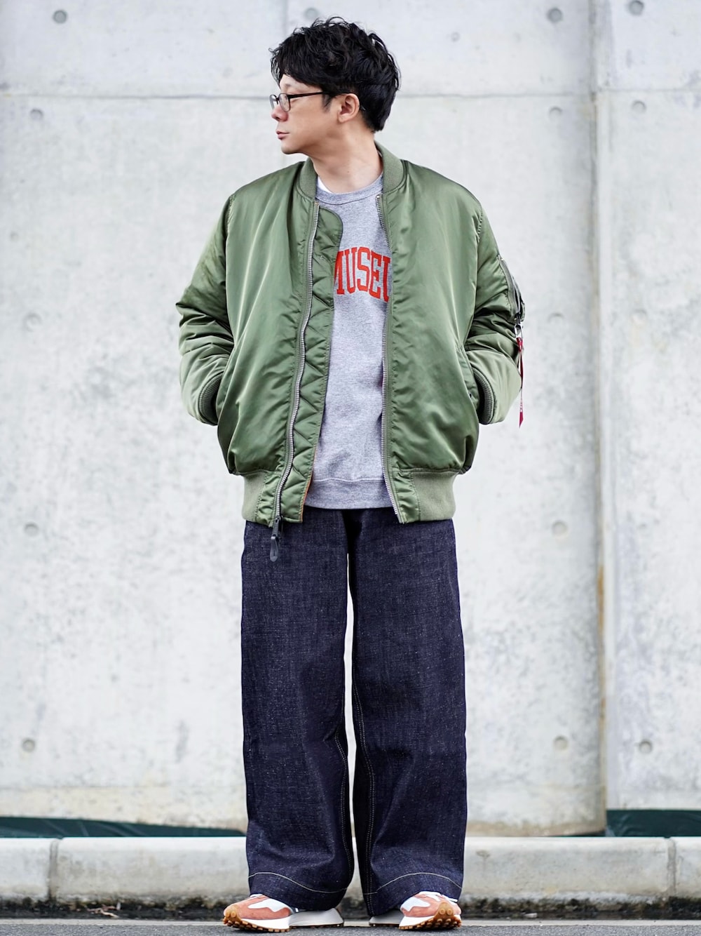 グリーン系のMA-1、グレー系のスウェット、ブルー系のデニムパンツを着用したメンズの秋コーディネートの1枚目の写真