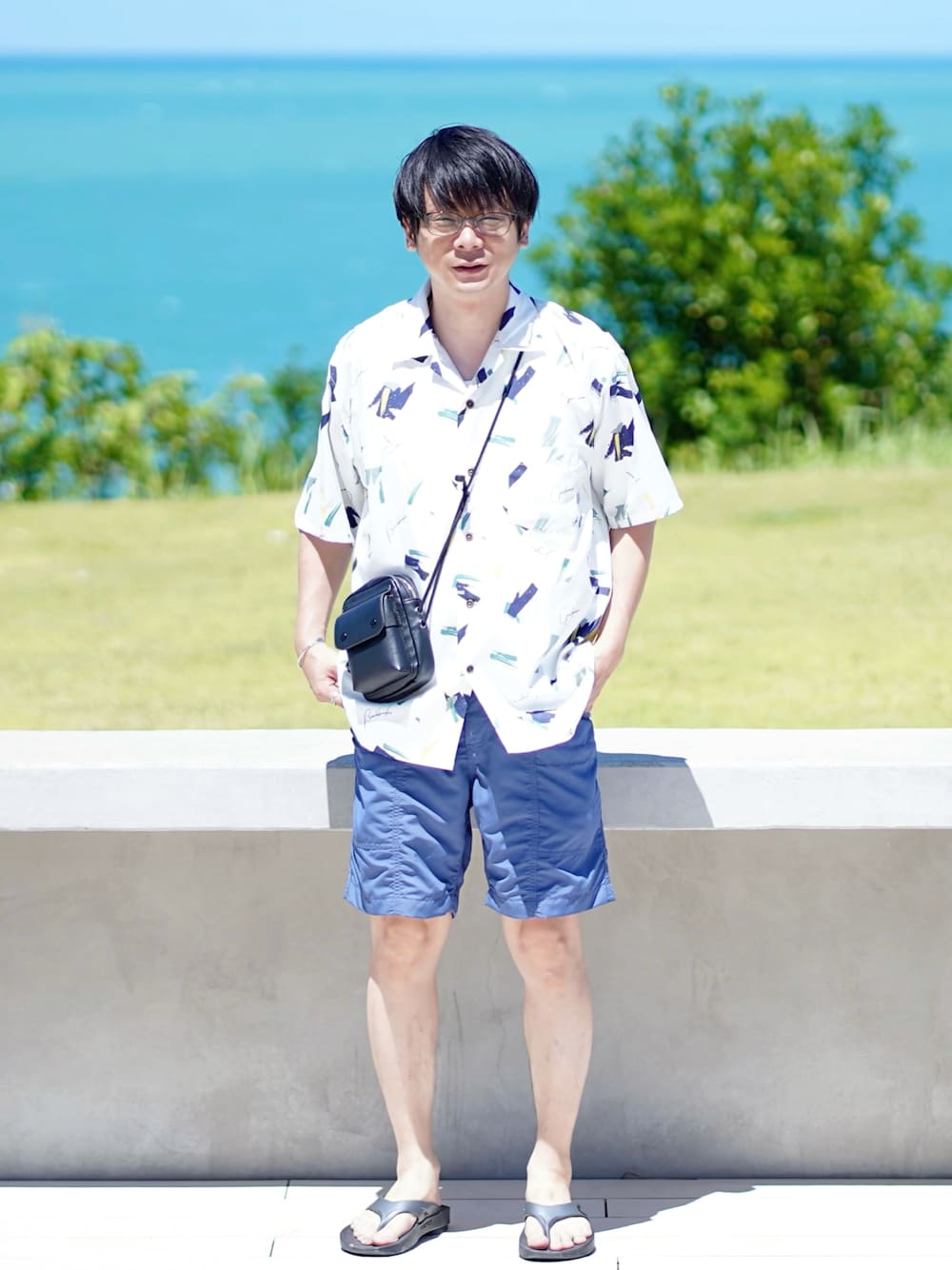 ホワイト系のシャツ/ブラウス、ブルー系のパンツ、ブラック系のサンダルを着用したメンズの夏コーディネートの1枚目の写真