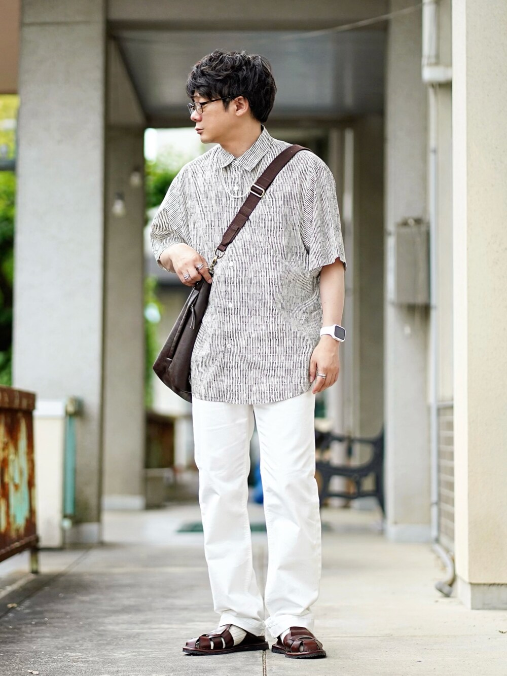 ホワイト系のデニムパンツ、ベージュ系のシャツ/ブラウス、ブラウン系のサンダルを着用したメンズの夏コーディネートの1枚目の写真