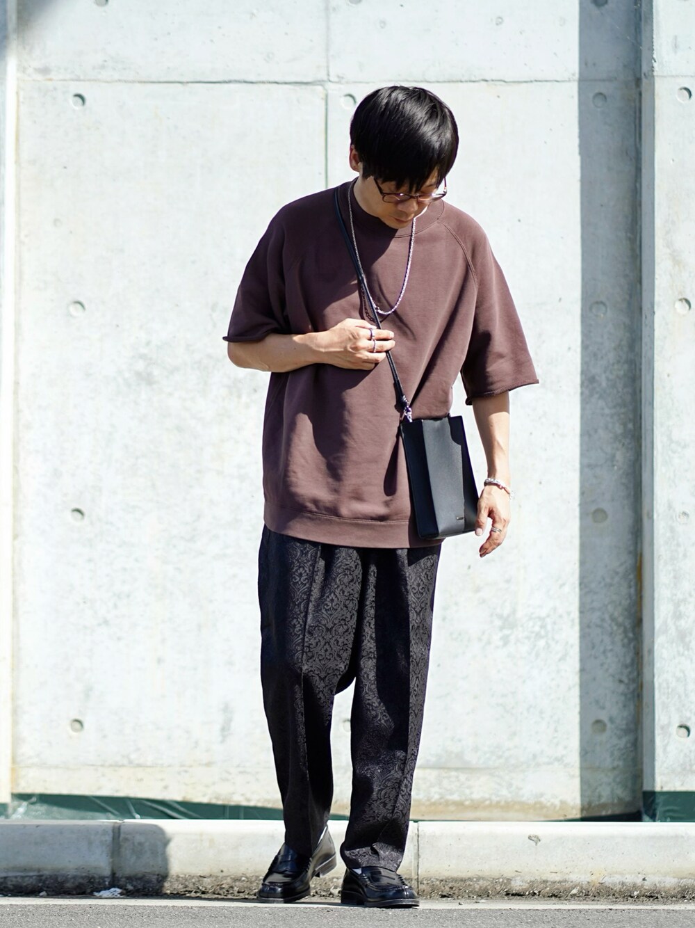 ブラウン系のTシャツ/カットソー、ブラック系のその他パンツ、ブラック系のローファーを着用したメンズの夏コーディネートの1枚目の写真