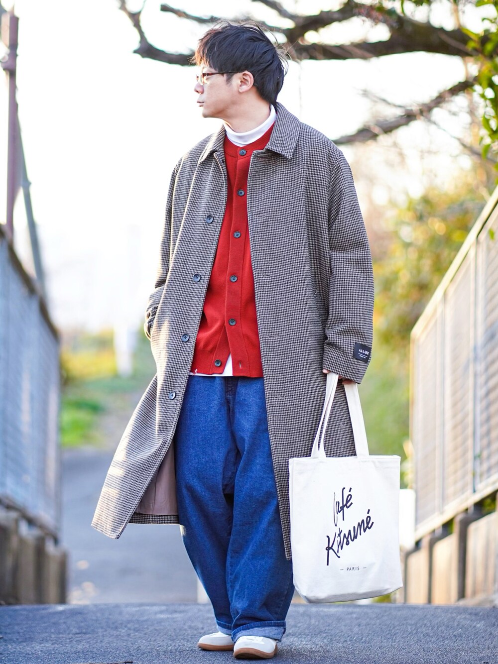 ブラウン系のステンカラーコート、レッド系のカーディガン/ボレロ、ホワイト系のTシャツ/カットソーを着用したメンズの冬コーディネートの1枚目の写真