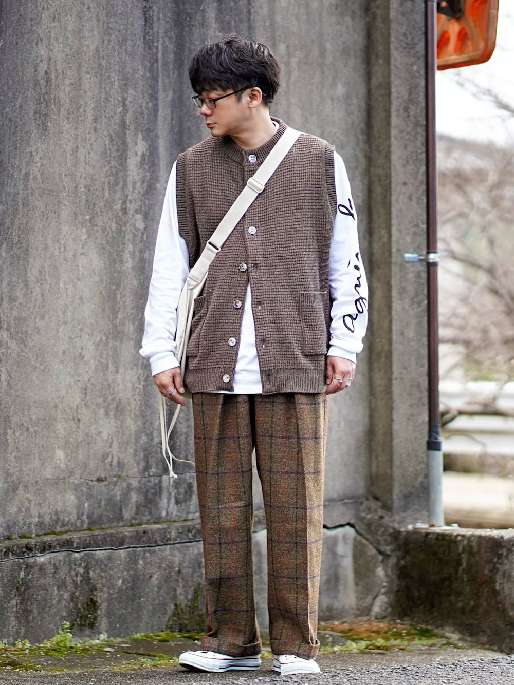 ホワイト系のTシャツ/カットソー、ブラウン系のベスト、ブラウン系のスラックスを着用したメンズの冬コーディネートの1枚目の写真
