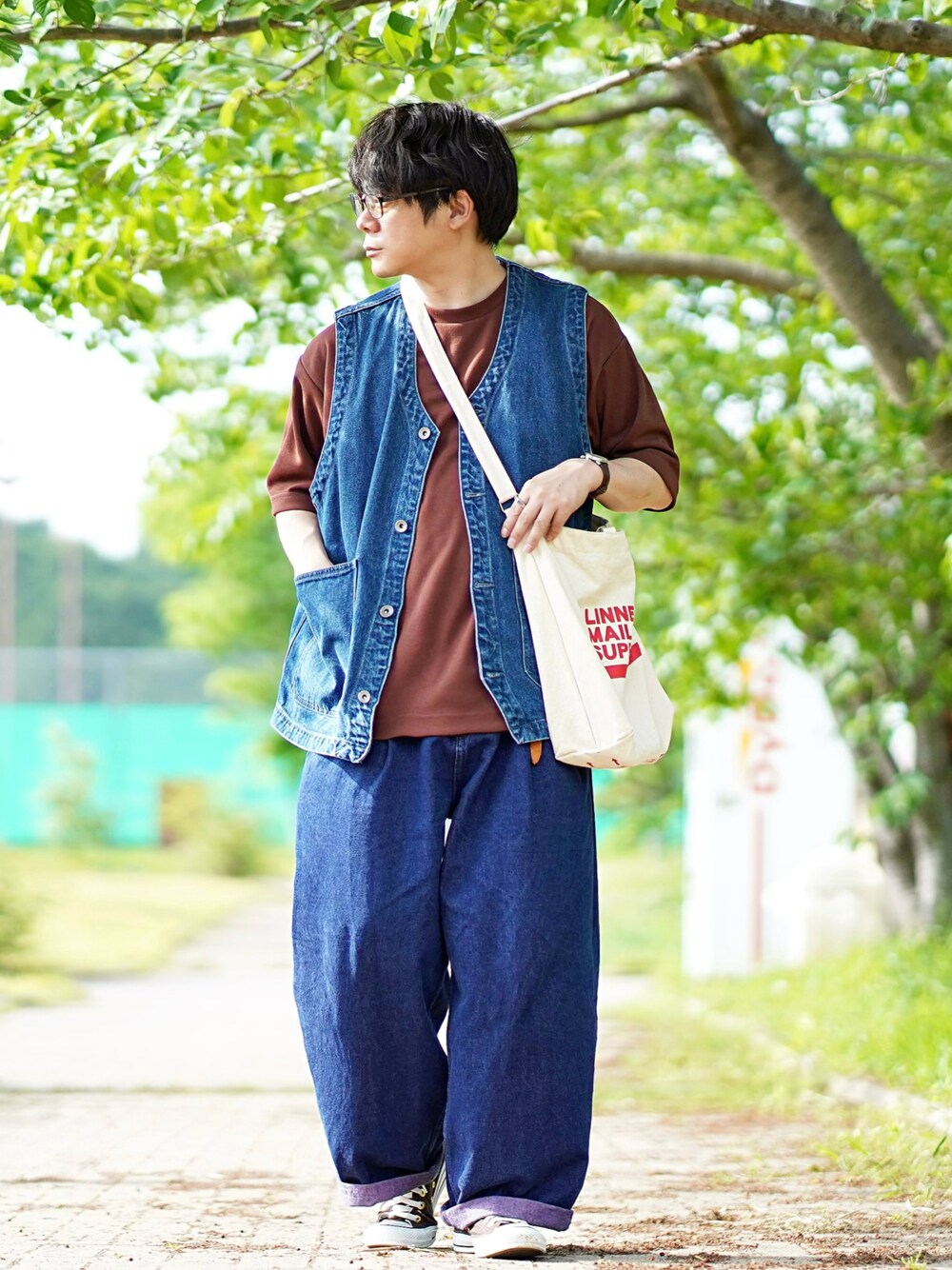ブラウン系のTシャツ/カットソー、ブルー系のベスト、ブルー系のデニムパンツを着用したメンズの夏コーディネートの1枚目の写真