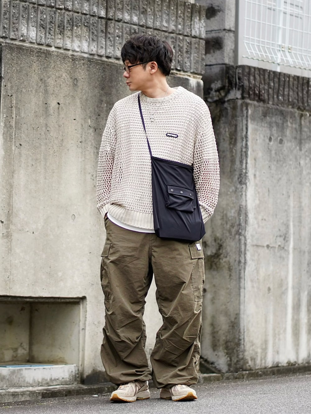 ベージュ系のニット/セーター、ホワイト系のTシャツ/カットソー、グリーン系のカーゴパンツを着用したメンズの春コーディネートの1枚目の写真