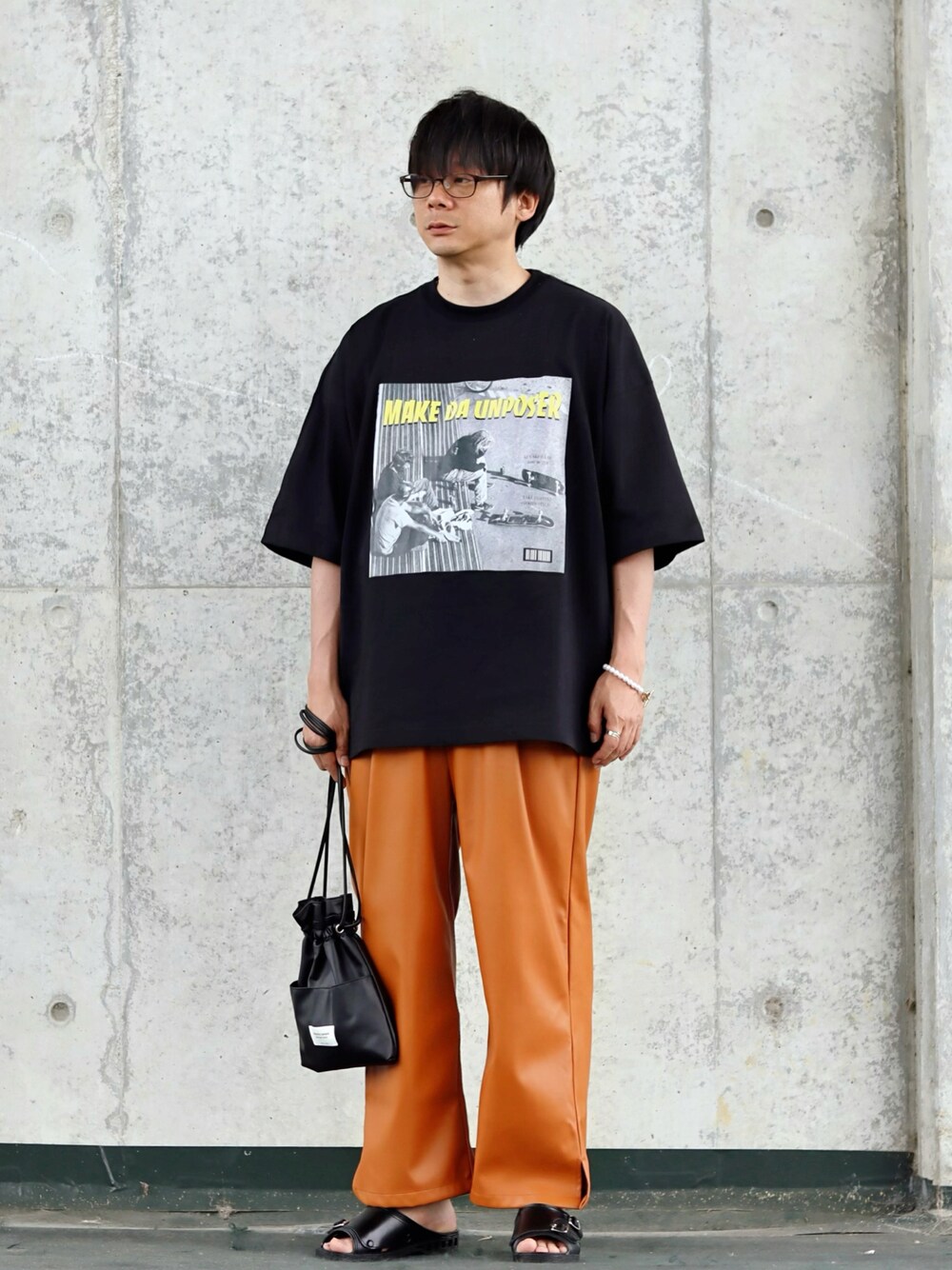 ブラック系のTシャツ/カットソー、ブラウン系のその他パンツ、ブラック系のサンダルを着用したメンズの夏コーディネートの1枚目の写真