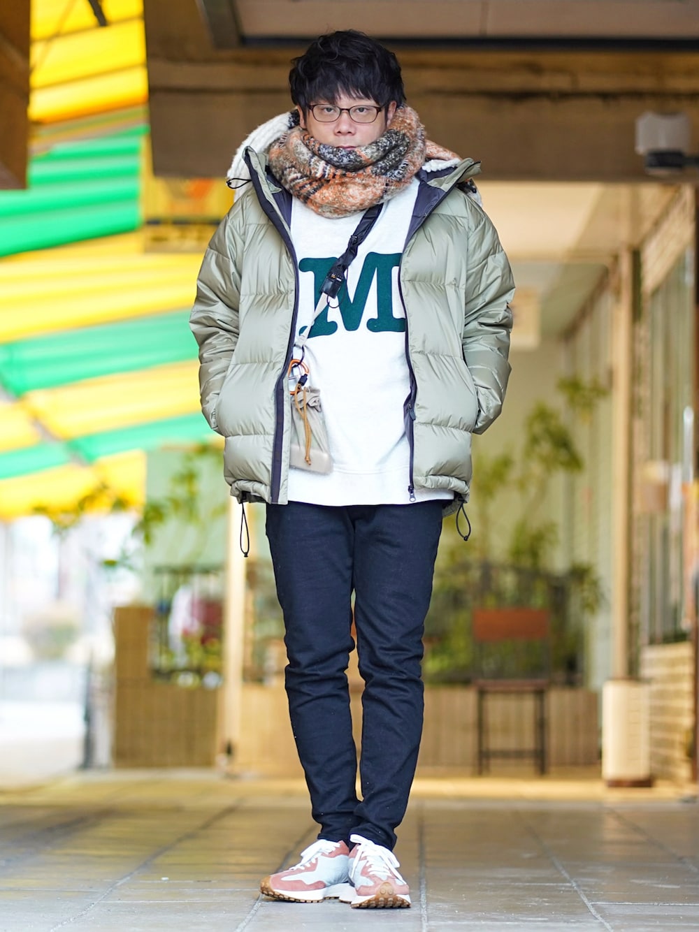 グリーン系のダウンジャケット/コート、ホワイト系のスウェット、ブラック系のデニムパンツを着用したメンズの冬コーディネートの1枚目の写真