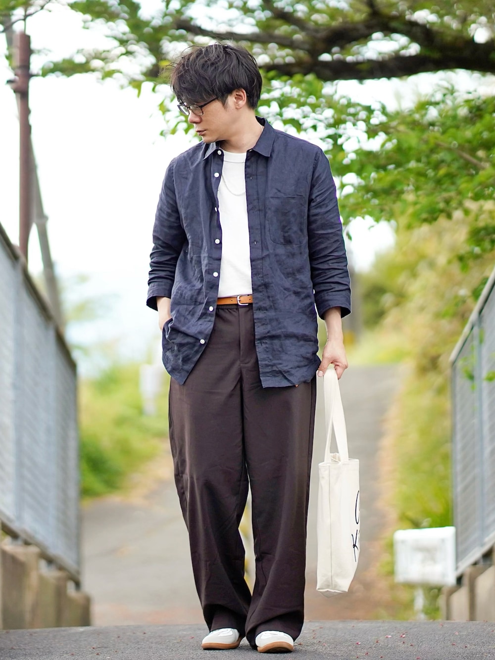 ブルー系のシャツ/ブラウス、ホワイト系のTシャツ/カットソー、ブラウン系のスラックスを着用したメンズの春コーディネートの1枚目の写真