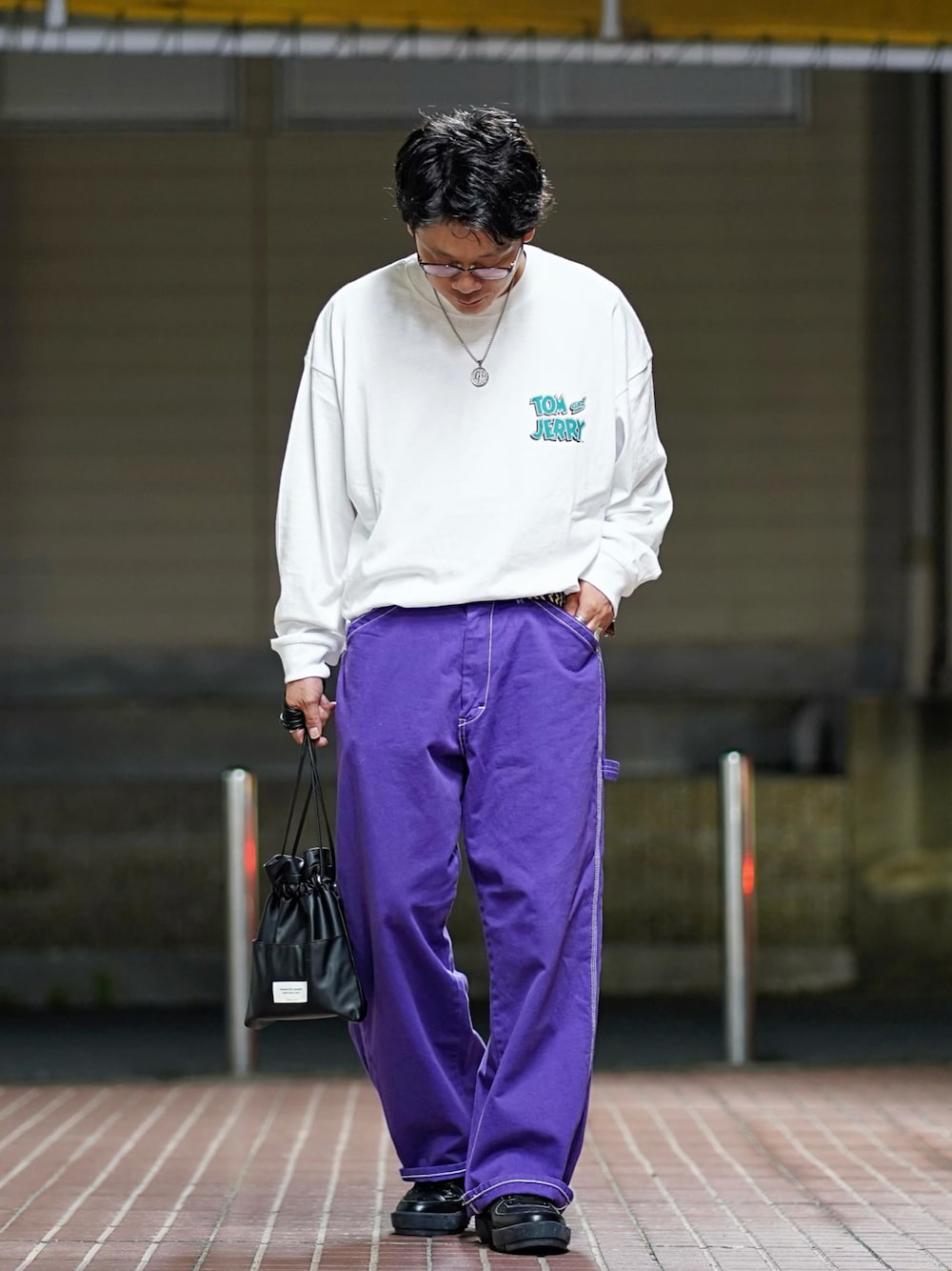 ホワイト系のTシャツ/カットソー、パープル系のデニムパンツ、ブラック系のスニーカーを着用したメンズの秋コーディネートの1枚目の写真