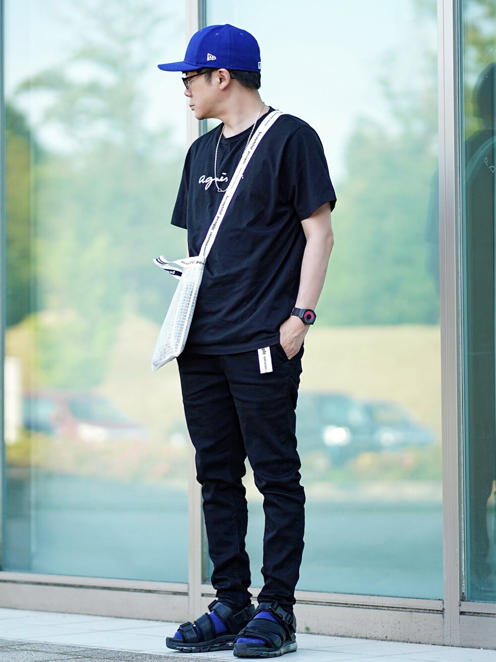 ブラック系のTシャツ/カットソー、ブラック系のデニムパンツ、ブラック系のサンダルを着用したメンズの春コーディネートの1枚目の写真