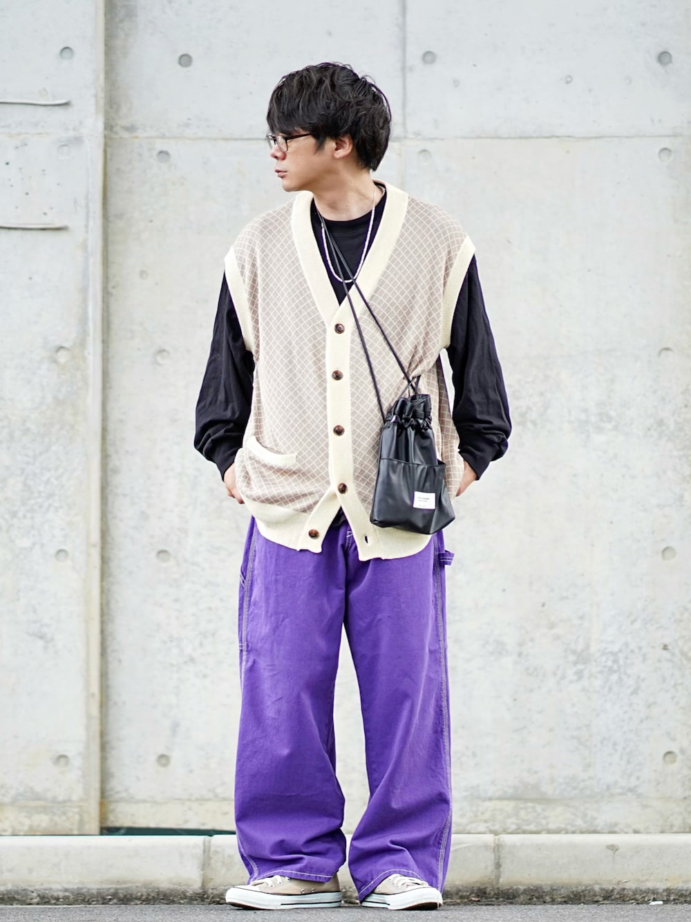 パープル系のデニムパンツ、ブラック系のTシャツ/カットソー、ベージュ系のニット/セーターを着用したメンズの秋コーディネートの1枚目の写真