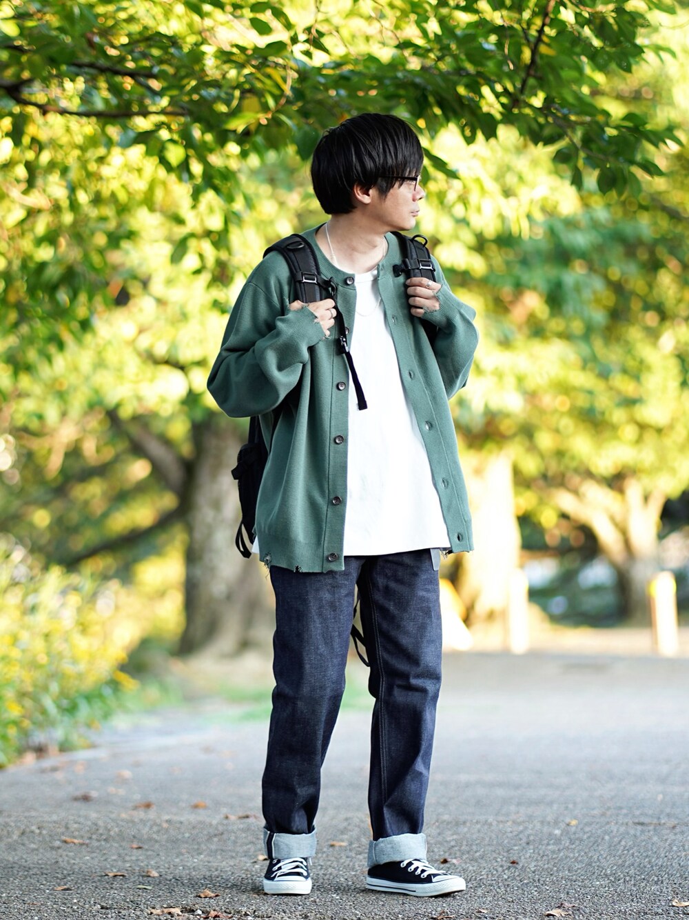 グリーン系のカーディガン/ボレロ、ホワイト系のTシャツ/カットソー、ブルー系のデニムパンツを着用したメンズの秋コーディネートの1枚目の写真