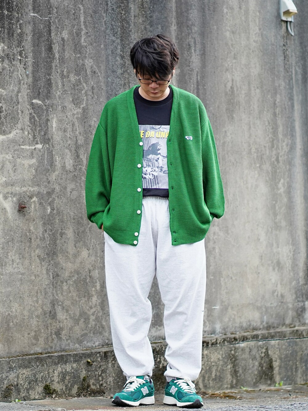 グリーン系のカーディガン/ボレロ、ブラック系のTシャツ/カットソー、グレー系のスウェットパンツを着用したメンズの秋コーディネートの1枚目の写真