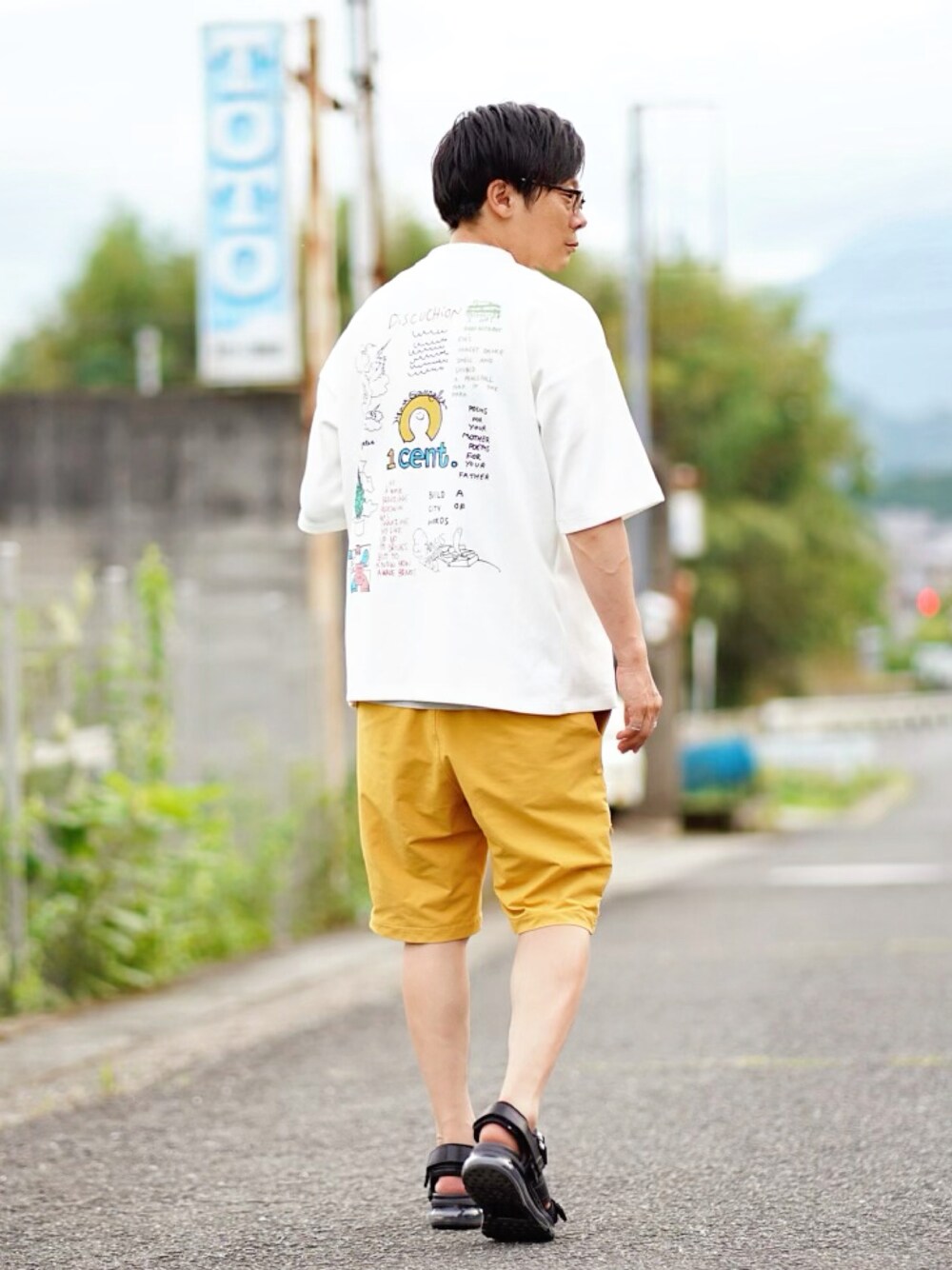 ホワイト系のTシャツ/カットソー、イエロー系のその他パンツ、ブラック系のサンダルを着用したメンズの夏コーディネートの1枚目の写真