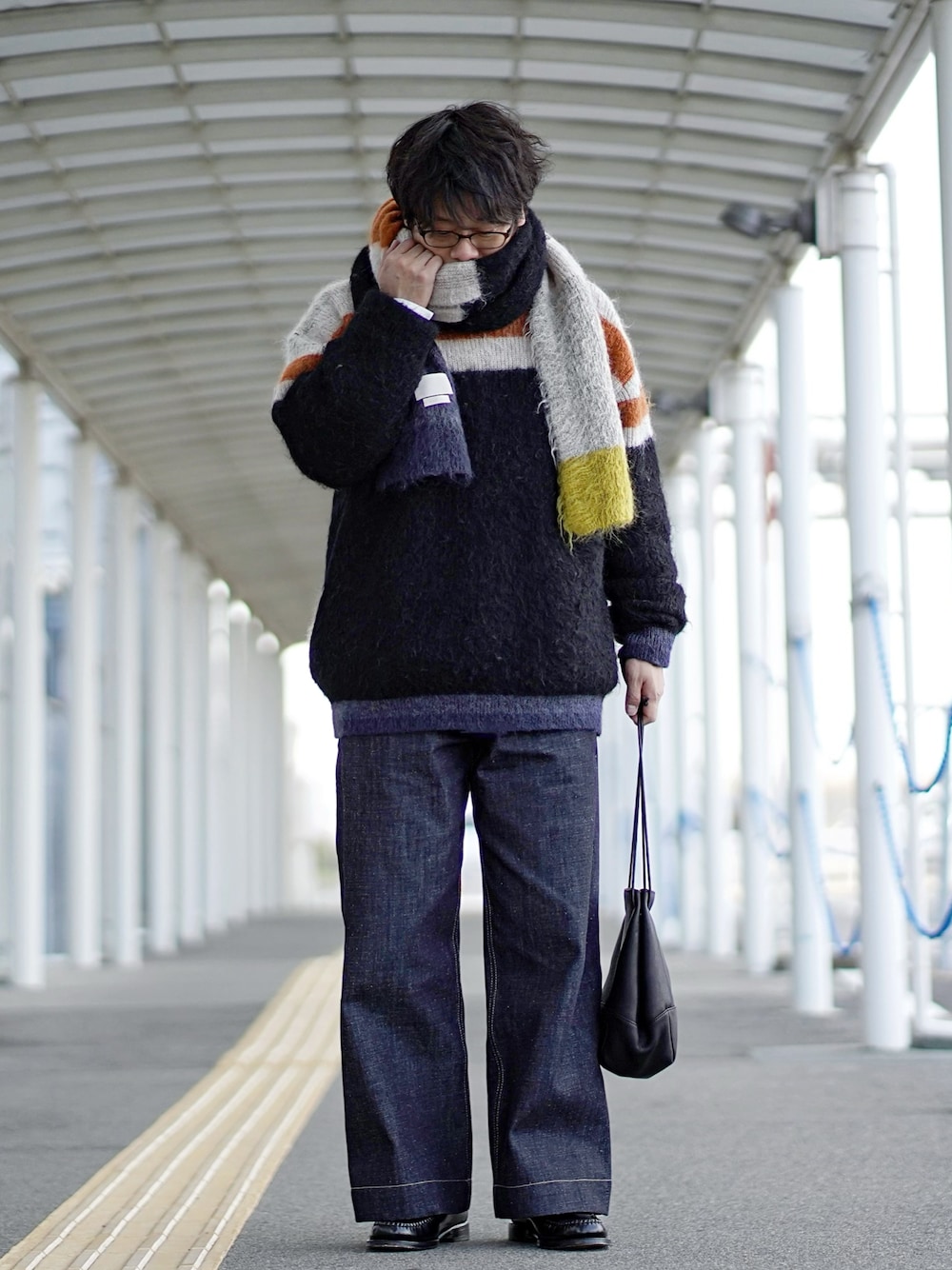 ブルー系のニット/セーター、ブルー系のデニムパンツ、ブラック系のローファーを着用したメンズの冬コーディネートの1枚目の写真