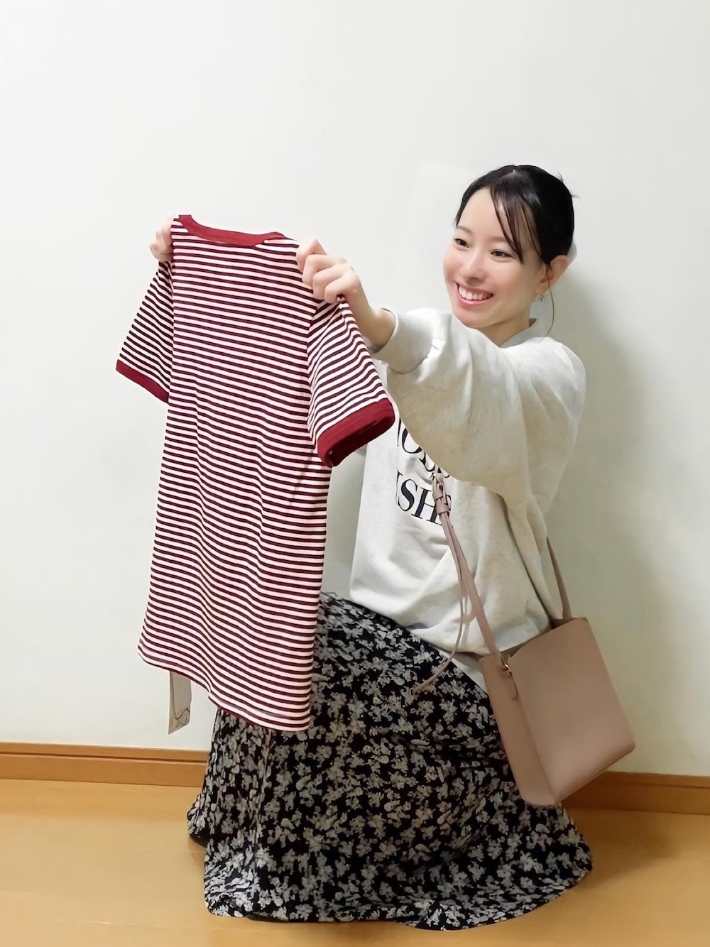 ブラック系のスカート、グレー系のスウェット、ベージュ系のショルダーバッグを着用したレディースの春コーディネートの1枚目の写真