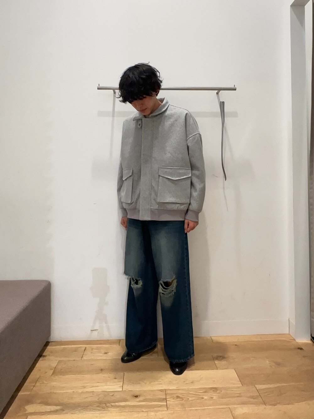 グレー系のブルゾン、ブルー系のデニムパンツ、ホワイト系のニット/セーターを着用したメンズの秋コーディネートの1枚目の写真