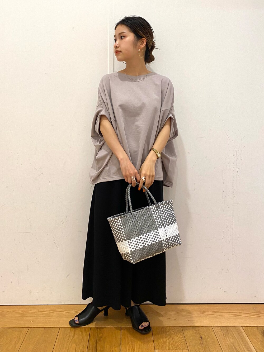 ベージュ系のTシャツ/カットソー、ブラック系のサンダル、シルバー系のトートバッグを着用したレディースの夏コーディネートの1枚目の写真