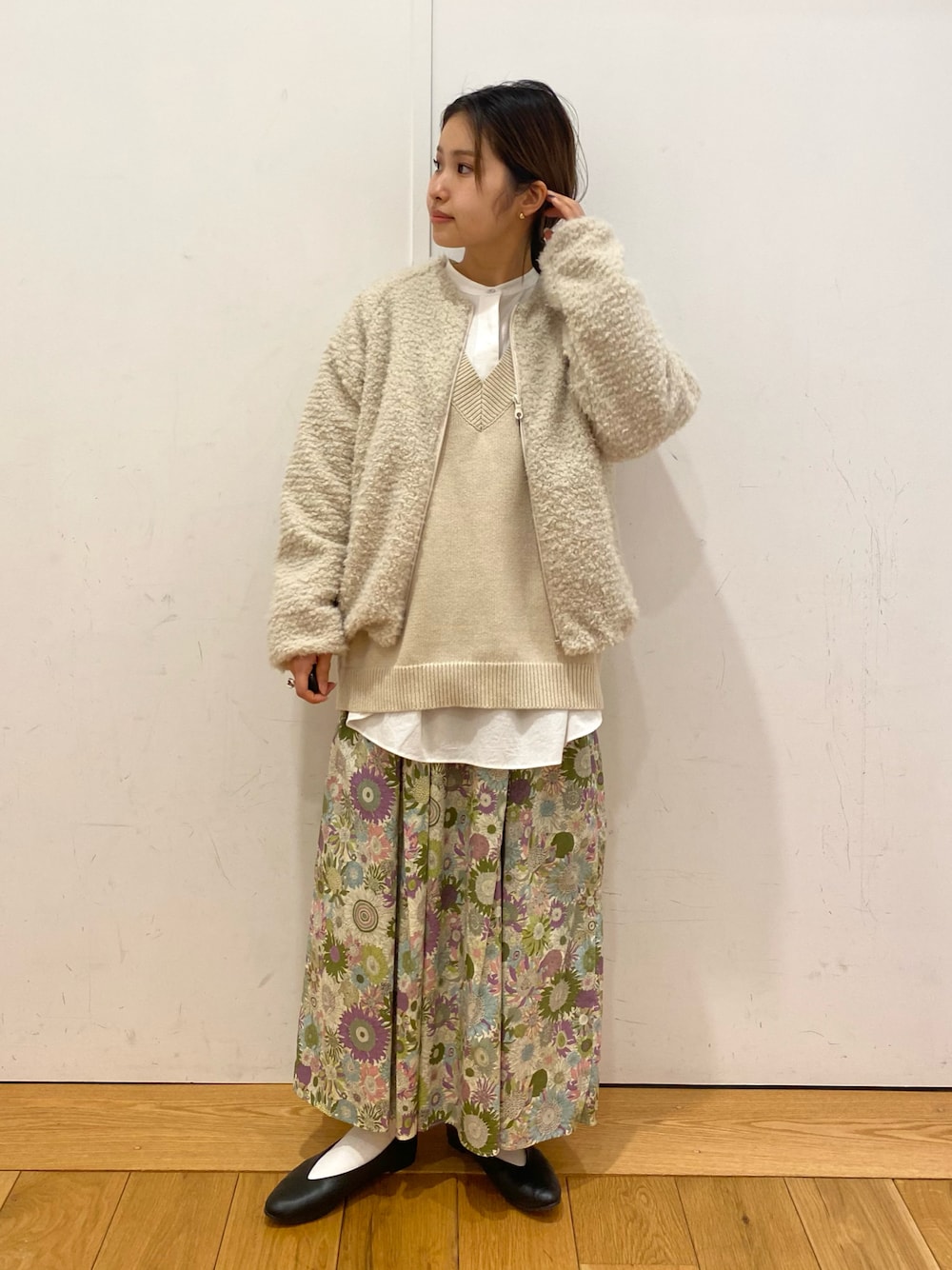 ブラック系のパンプス、ブラック系のスカート、ホワイト系のシャツ/ブラウスを着用したレディースの冬コーディネートの1枚目の写真