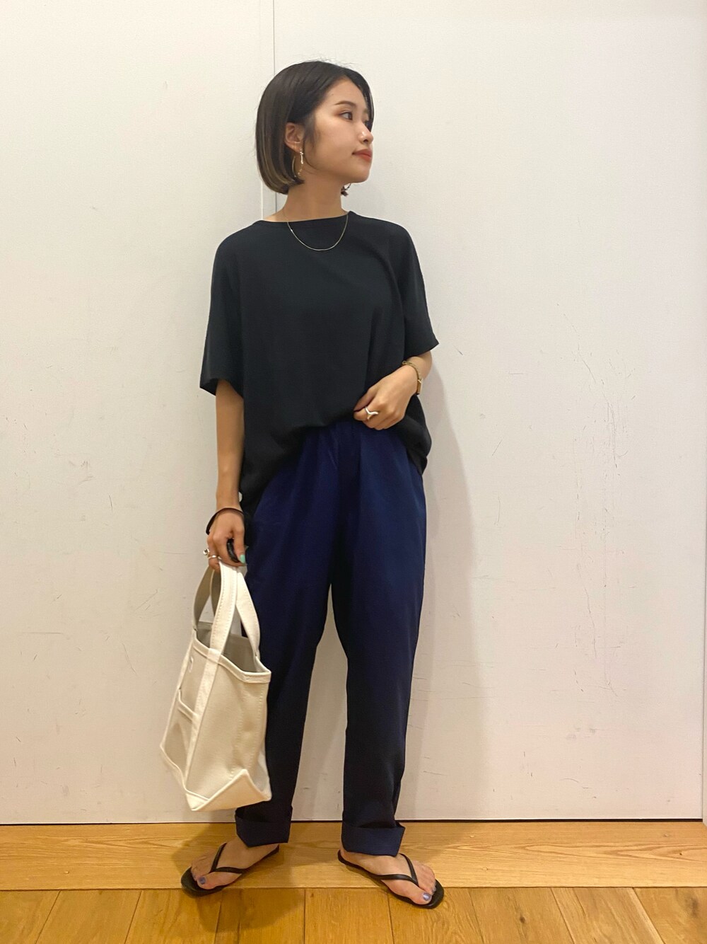 ブルー系のその他パンツ、ホワイト系のトートバッグ、ブラック系のサンダルを着用したレディースの秋コーディネートの1枚目の写真