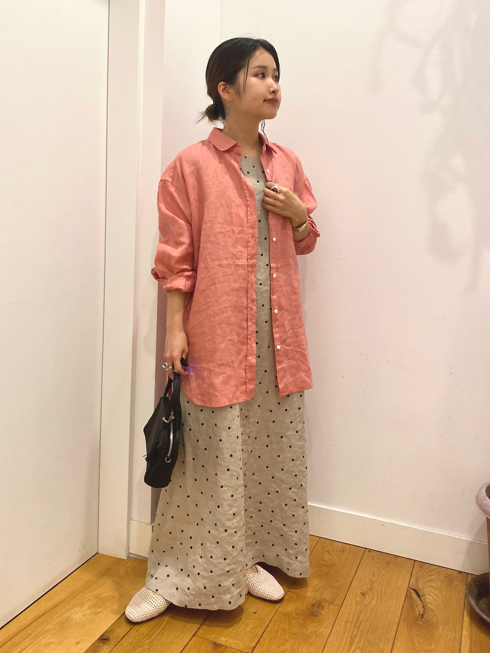 ピンク系のシャツ/ブラウス、ベージュ系のワンピース、ホワイト系のサンダルを着用したレディースの春コーディネートの1枚目の写真