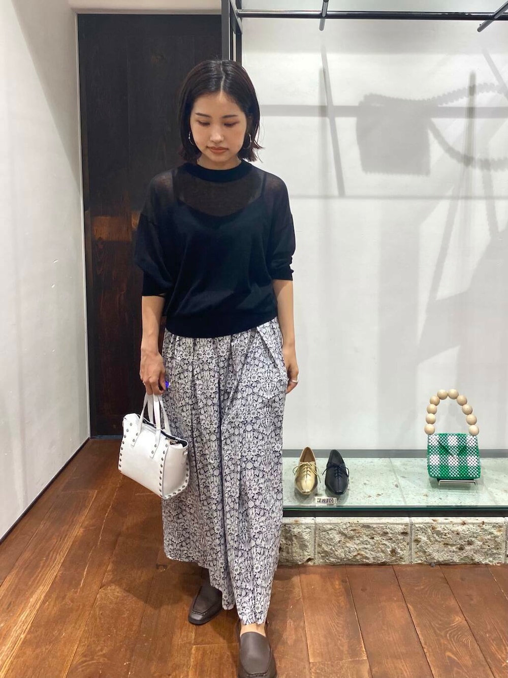 ブラウン系のサンダル、ブルー系のニット/セーター、ホワイト系のショルダーバッグを着用したレディースの夏コーディネートの1枚目の写真