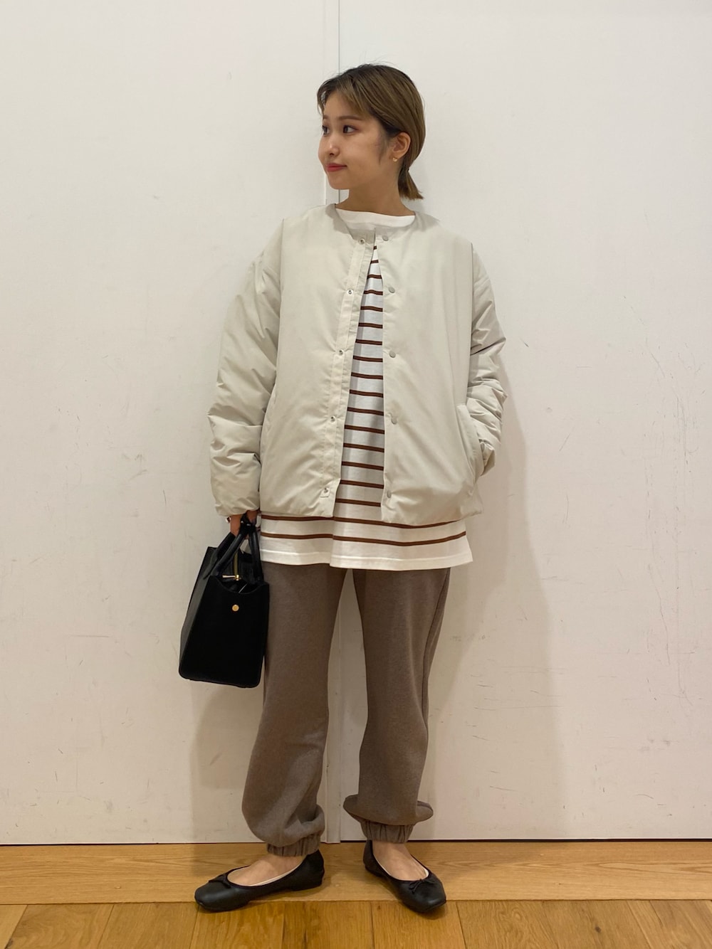 ブラウン系のスウェットパンツ、ブラウン系のTシャツ/カットソー、ブラック系のショルダーバッグを着用したレディースの秋コーディネートの1枚目の写真