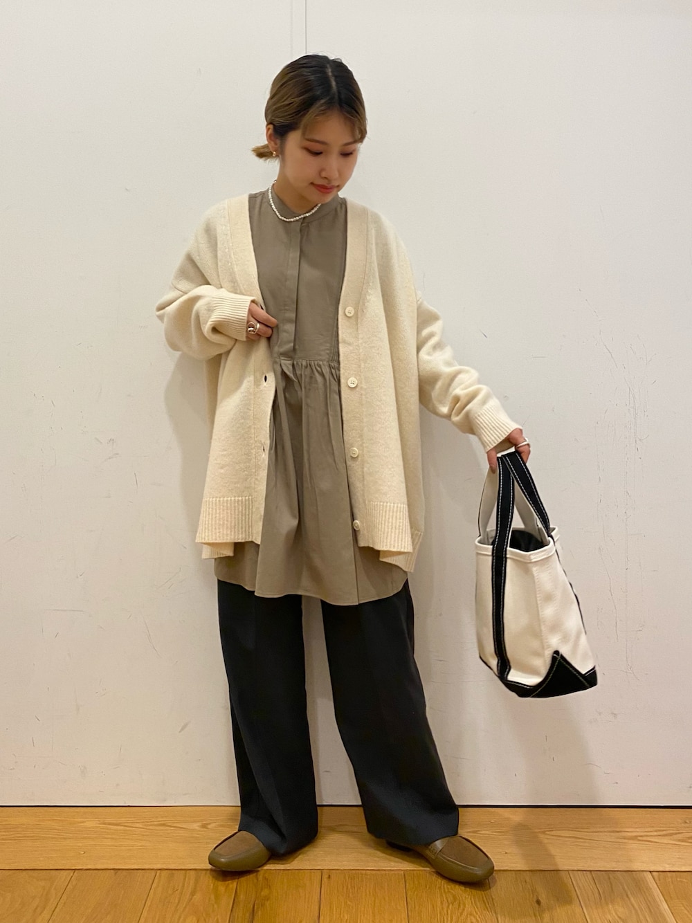 ホワイト系のカーディガン/ボレロ、グレー系のシャツ/ブラウス、グレー系のその他パンツを着用したレディースの冬コーディネートの1枚目の写真