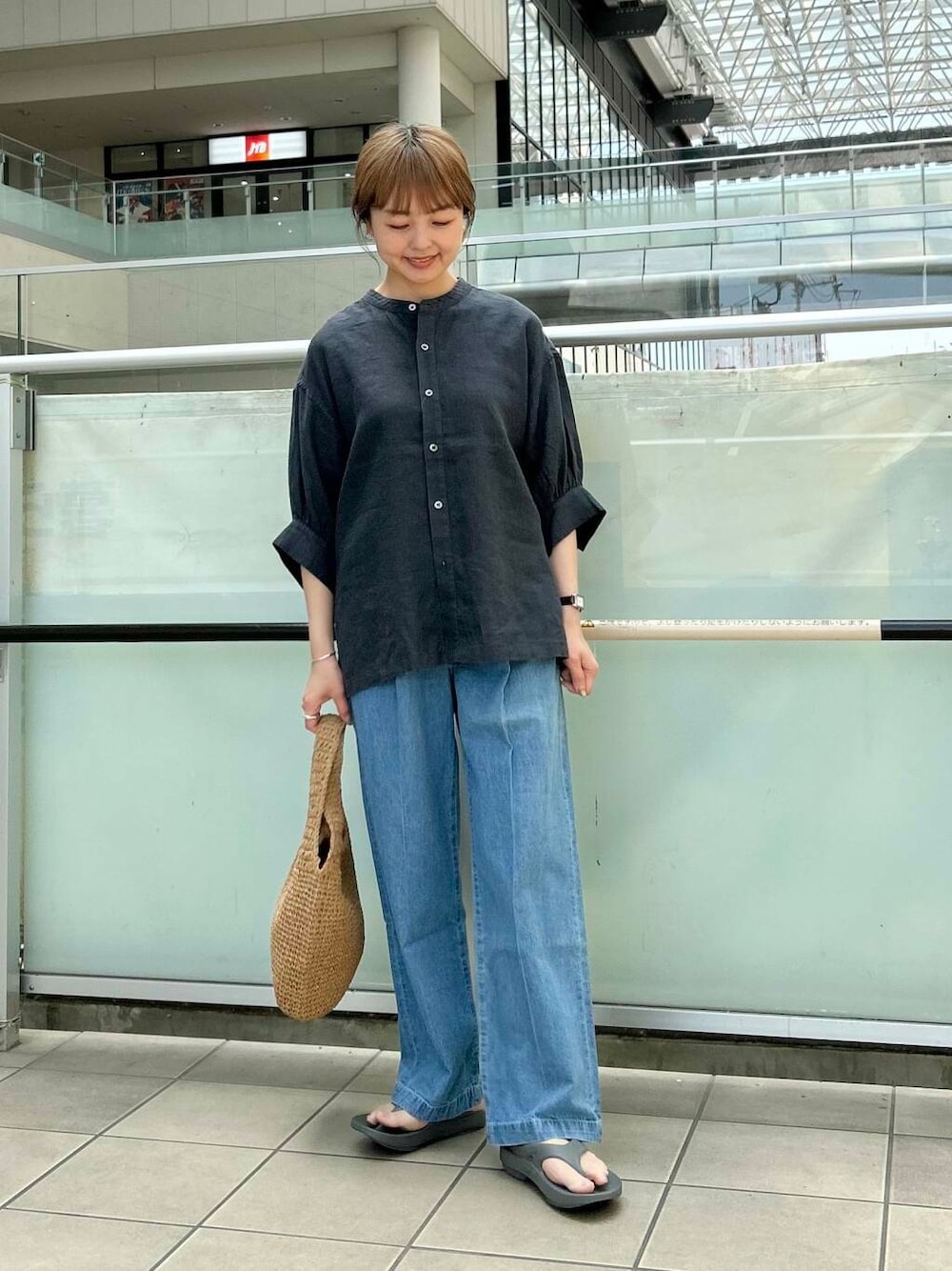 イエロー系のトートバッグ、グレー系のシャツ/ブラウス、グレー系のサンダルを着用したレディースの春コーディネートの1枚目の写真