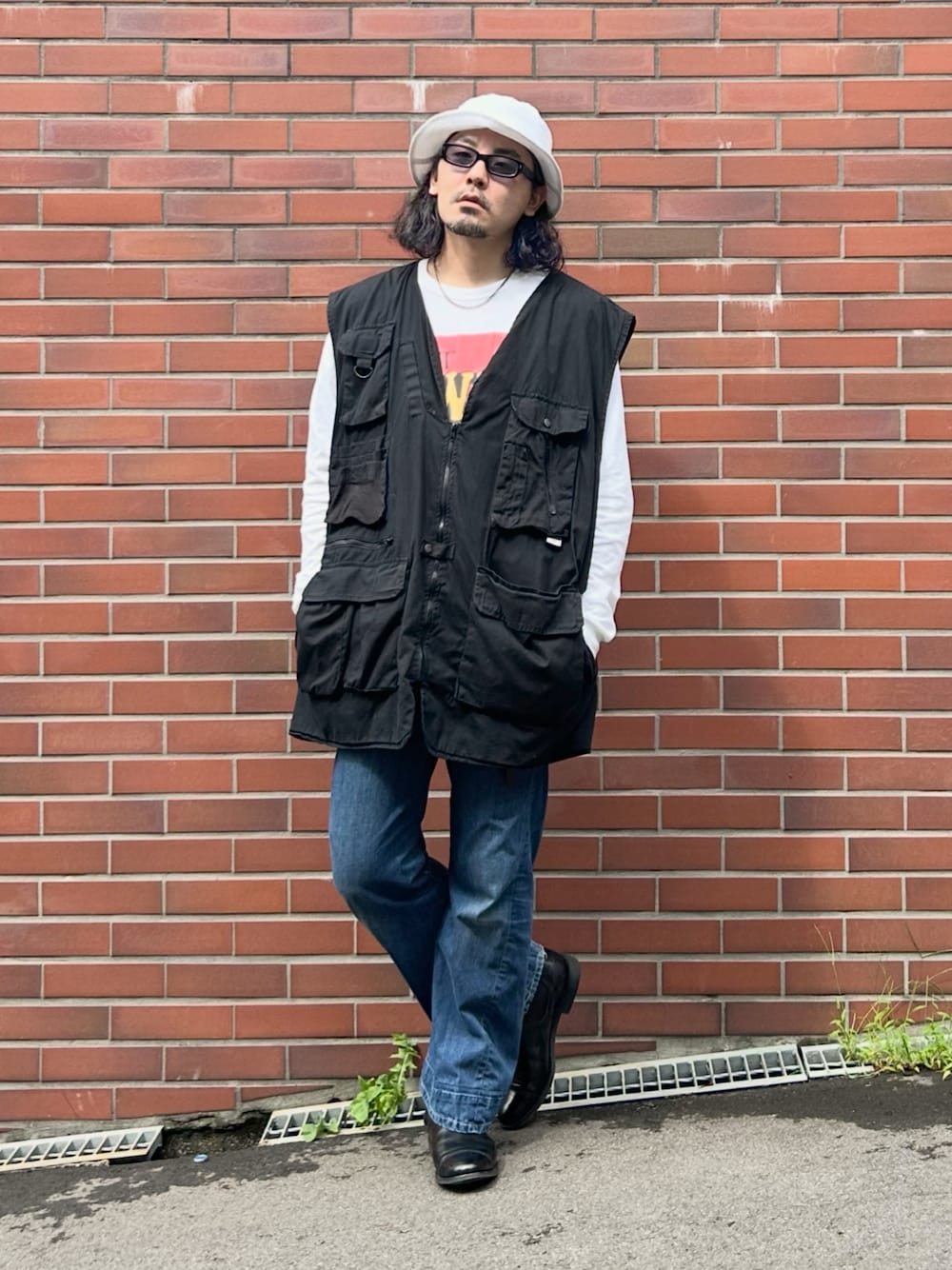 ブラック系のブーツ、ブラック系のベスト、ホワイト系のTシャツ/カットソーを着用したメンズの秋コーディネートの1枚目の写真