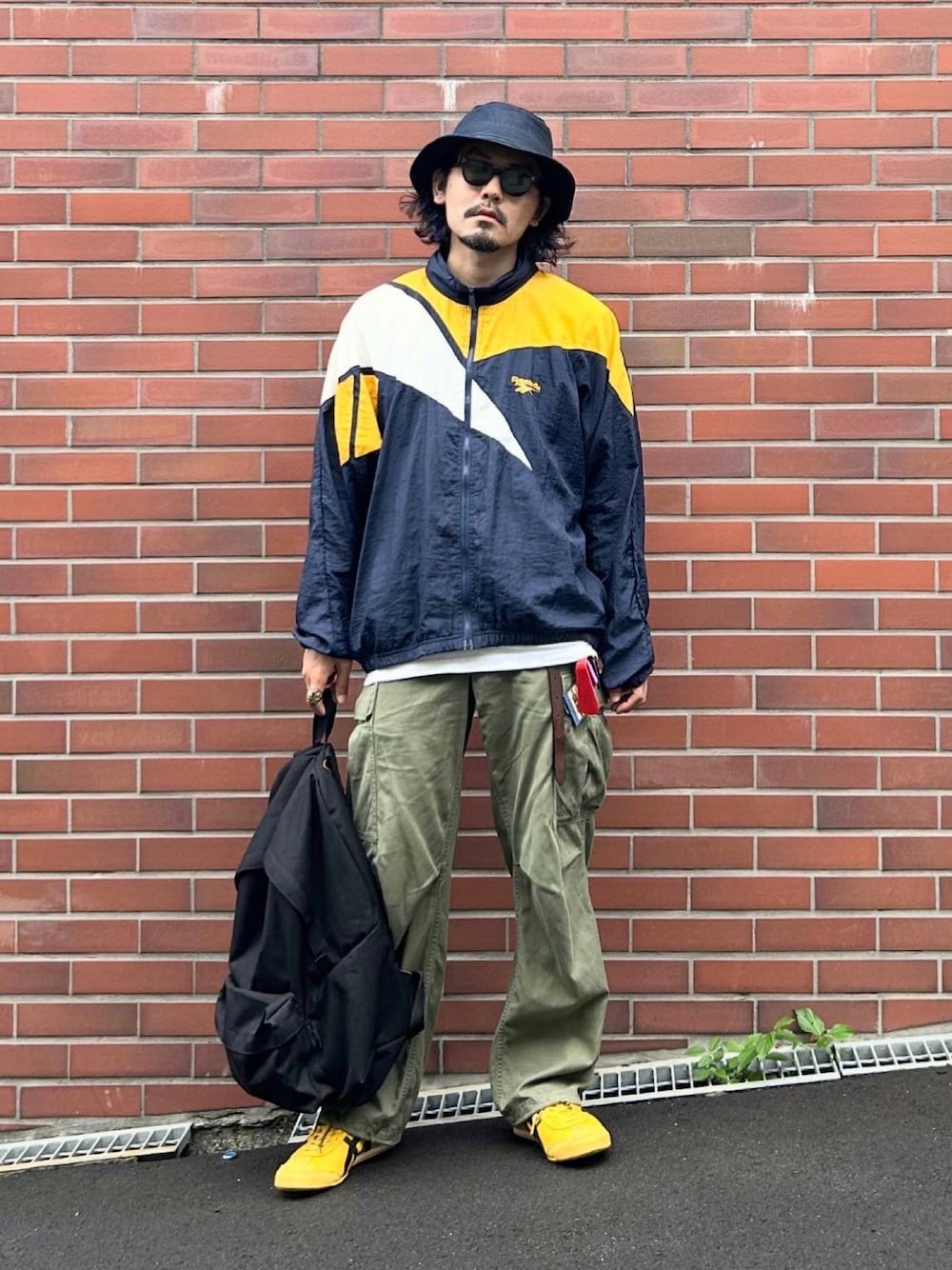 ホワイト系のTシャツ/カットソー、イエロー系のスニーカー、ブルー系のナイロンジャケットを着用したメンズの秋コーディネートの1枚目の写真