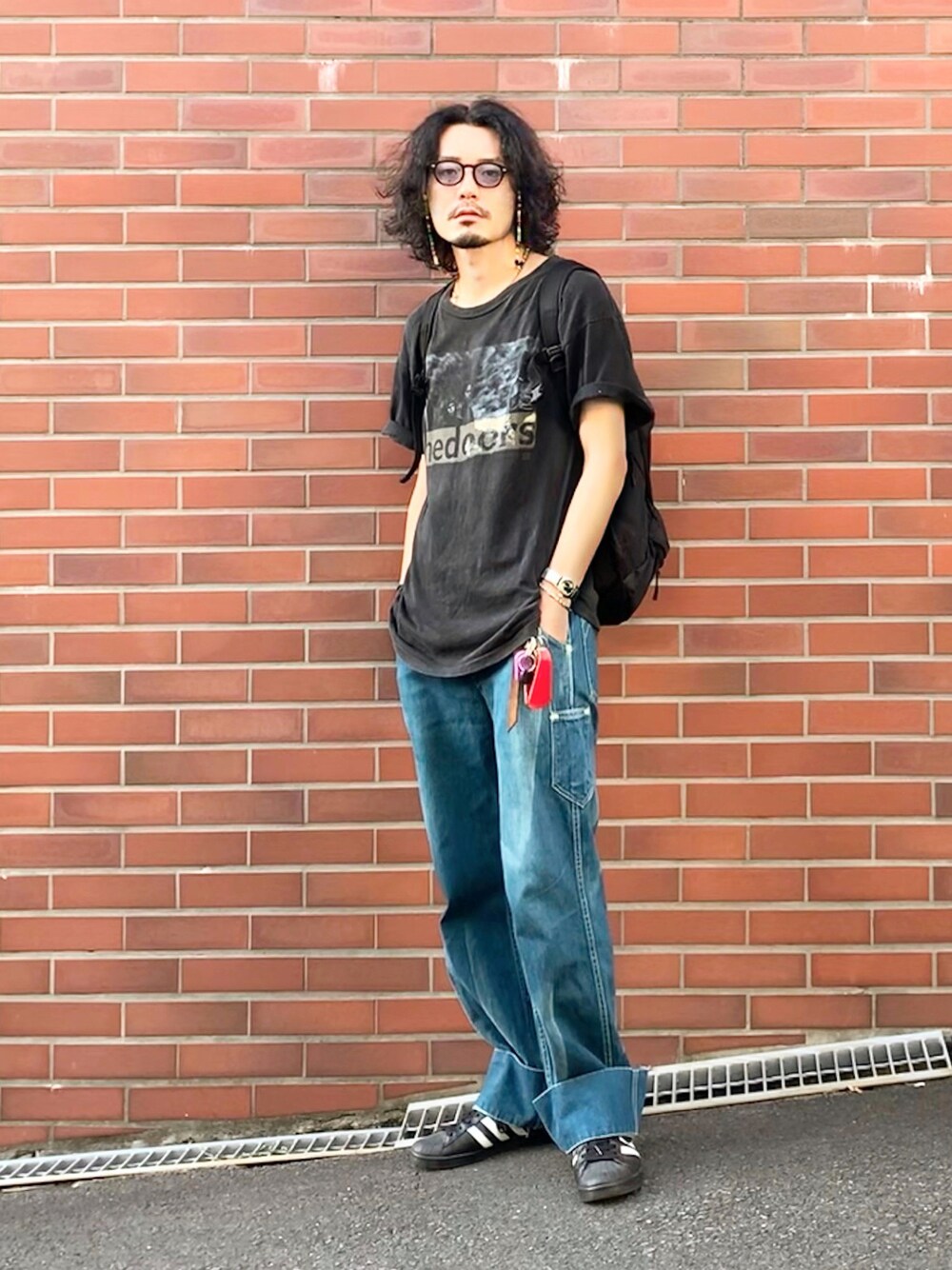 ブラック系のTシャツ/カットソー、ブルー系のデニムパンツ、ブラック系のスニーカーを着用したメンズの夏コーディネートの1枚目の写真