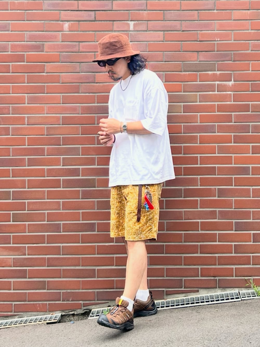 グレー系のタンクトップ、ホワイト系のTシャツ/カットソー、ブラウン系のスニーカーを着用したメンズの秋コーディネートの1枚目の写真