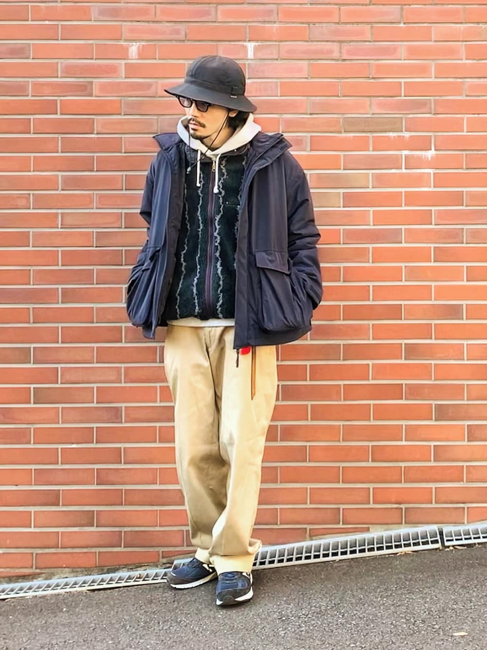 ブルー系のミリタリージャケット、グリーン系のその他アウター、グレー系のパーカーを着用したメンズの冬コーディネートの1枚目の写真