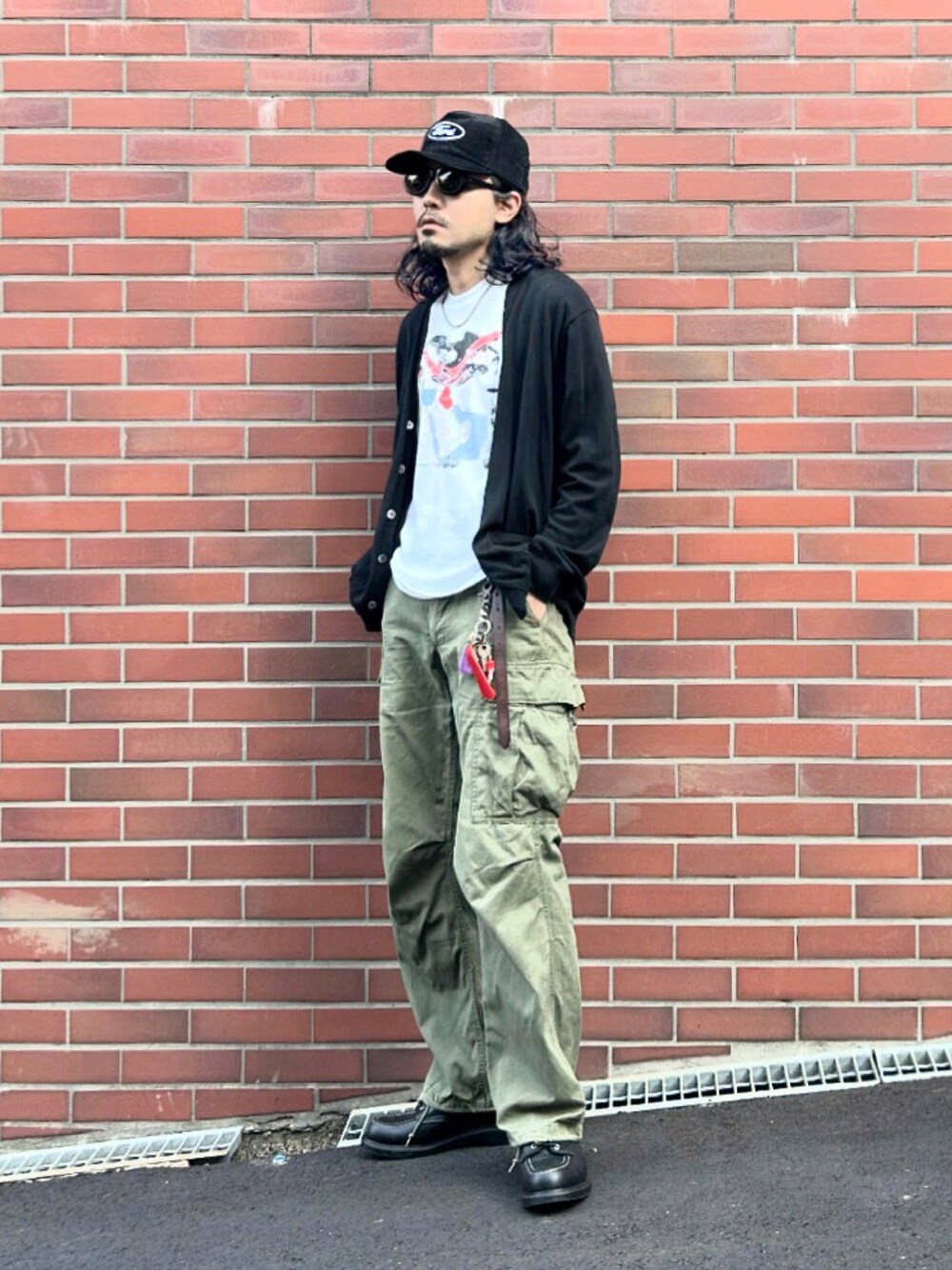 ブラック系のカーディガン/ボレロ、ホワイト系のTシャツ/カットソー、グリーン系のカーゴパンツを着用したメンズの秋コーディネートの1枚目の写真
