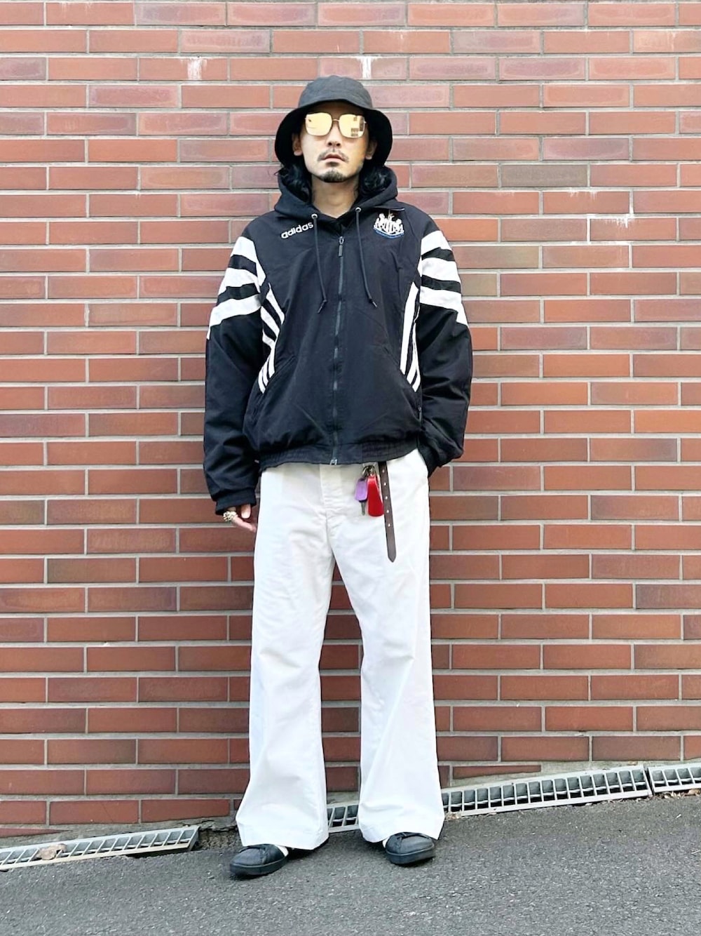 ブラック系のナイロンジャケット、ブラック系のパーカー、ブラック系のその他アウターを着用したメンズの冬コーディネートの1枚目の写真