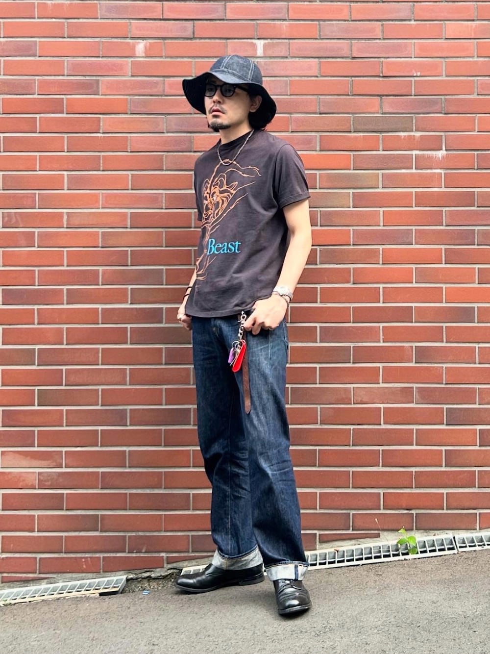 ブルー系のデニムパンツ、ブラック系のTシャツ/カットソー、ブラック系のドレスシューズを着用したメンズの夏コーディネートの1枚目の写真