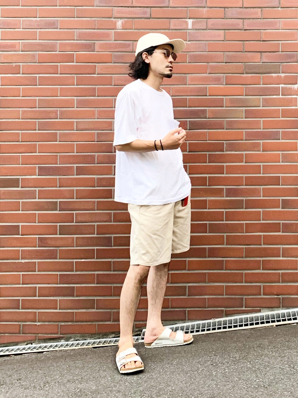 ホワイト系のTシャツ/カットソー、ベージュ系のチノパンツ、ホワイト系のサンダルを着用したメンズの夏コーディネートの1枚目の写真