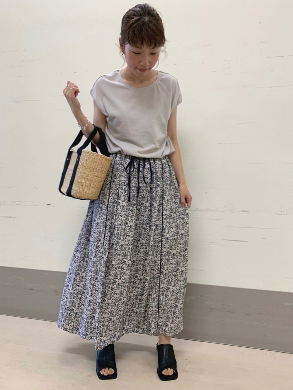 グレー系のワンピース/ドレス、ブラック系のかごバッグ、ブラック系のサンダルを着用したレディースの夏コーディネートの1枚目の写真