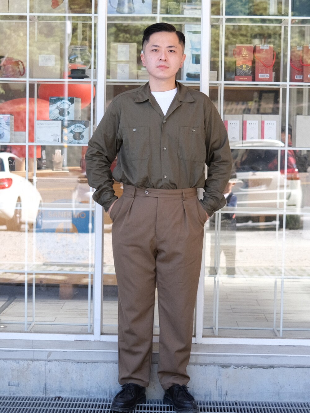 グリーン系のシャツ/ブラウス、ブラウン系のスラックス、ブラック系のシューズを着用したメンズの冬コーディネートの1枚目の写真