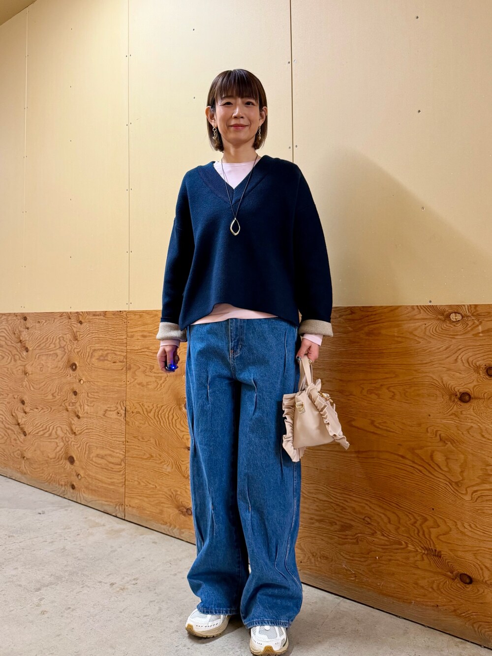 ブルー系のニット/セーター、ピンク系のTシャツ/カットソー、ブルー系のデニムパンツを着用したレディースの冬コーディネートの1枚目の写真