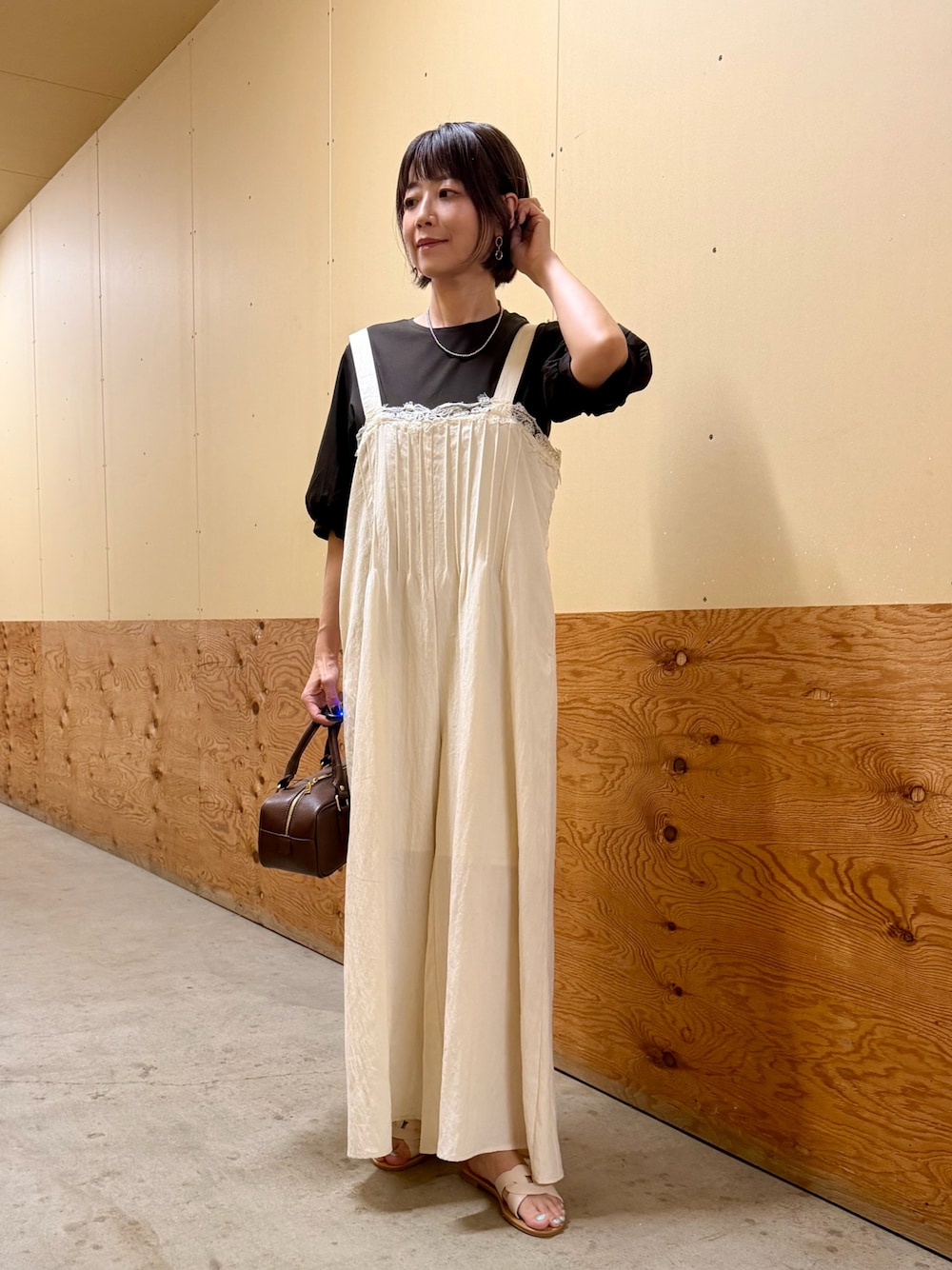 ブラウン系のTシャツ/カットソー、ホワイト系のその他パンツ、ブラウン系のハンドバッグを着用したレディースの夏コーディネートの1枚目の写真