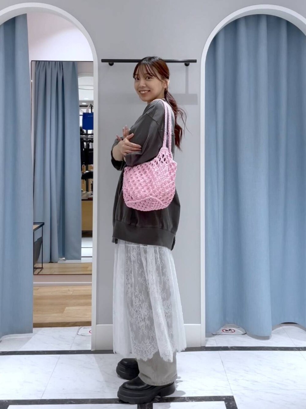 グレー系のデニムパンツ、ホワイト系のスカート、グレー系のTシャツ/カットソーを着用したレディースの春コーディネートの1枚目の写真