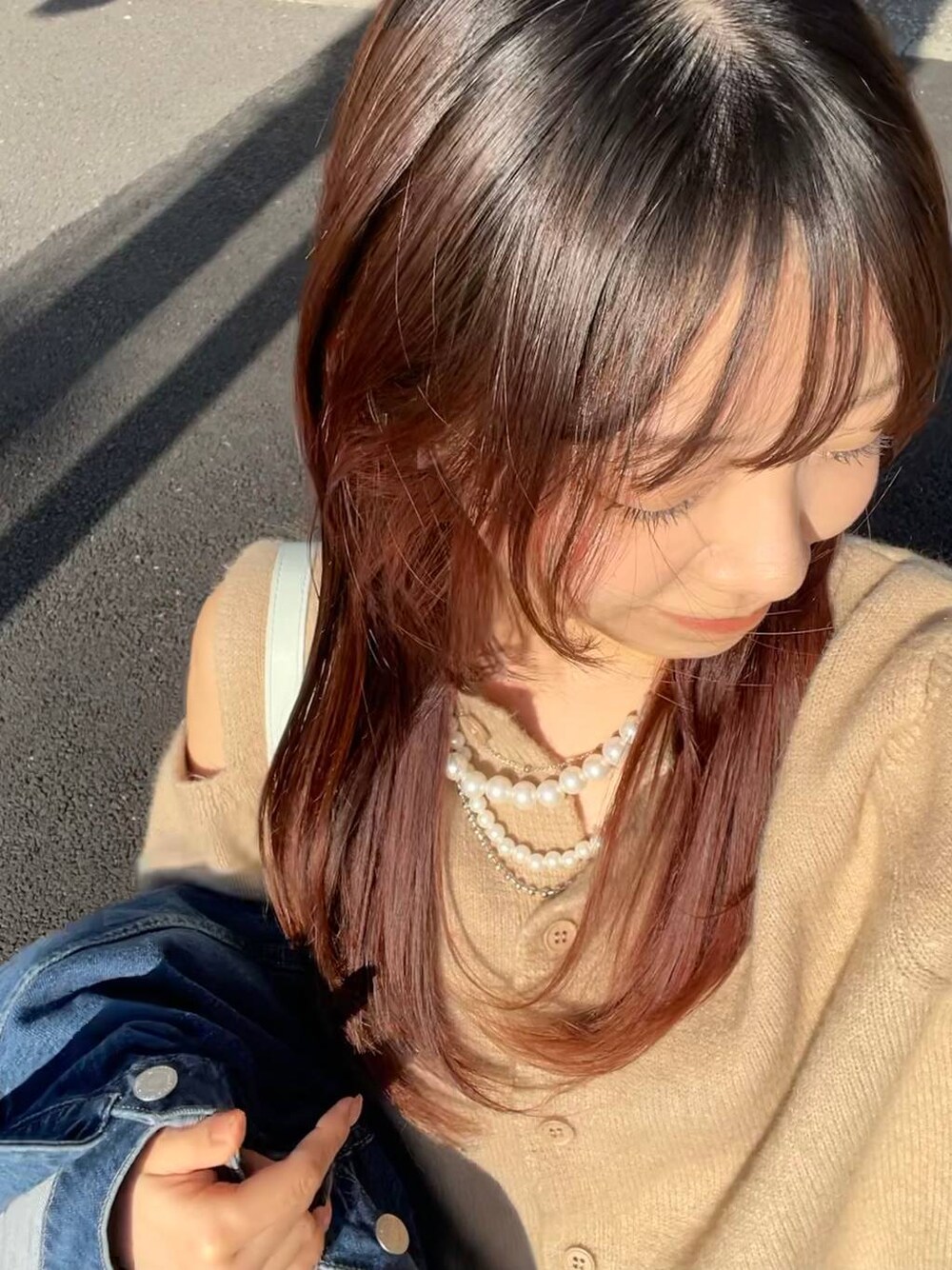 グリーン系のトートバッグ、ベージュ系のネックレスを着用したレディースの春コーディネートの1枚目の写真